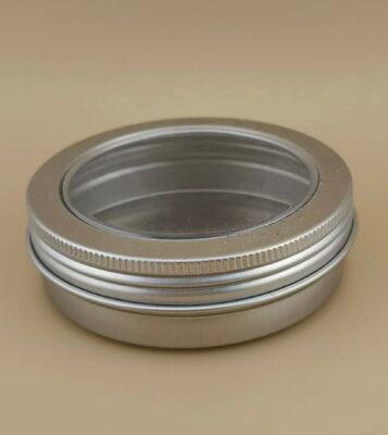 Une grande étui en aluminium argenté avec un bouchon à vis transparent pour les cosmétiques