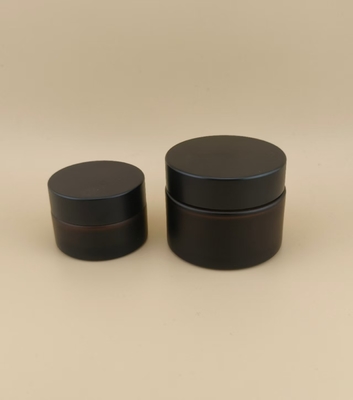Un bon design, un verre noir, un pot de crème avec un couvercle à vis pour la lotion.