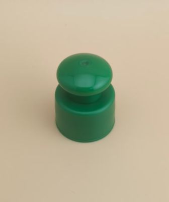 Bouchon lisse en plastique vert avec bouton pour flacons cosmétiques