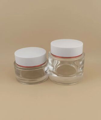 Couvercle blanc de bouteille transparente avec bord doré pour produit de soin de la peau