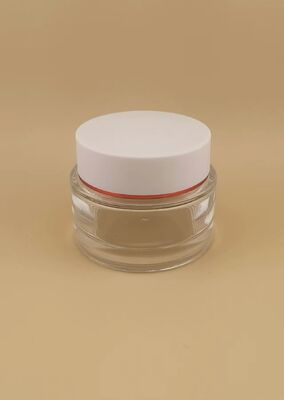 Couvercle blanc de bouteille transparente avec bord doré pour produit de soin de la peau
