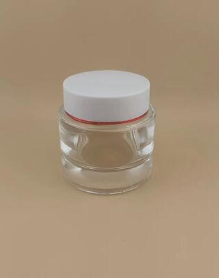 Couvercle blanc de bouteille transparente avec bord doré pour produit de soin de la peau