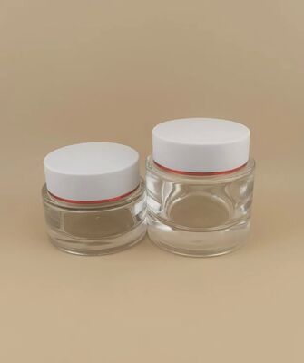Couvercle blanc de bouteille transparente avec bord doré pour produit de soin de la peau