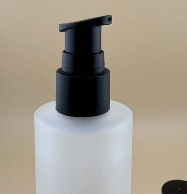 Bouteille en verre transparent mat avec pompe de traitement noire pour les cosmétiques
