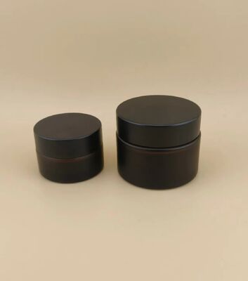 Un bon design, un verre noir, un pot de crème avec un couvercle à vis pour la lotion.