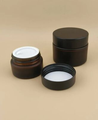 Un bon design, un verre noir, un pot de crème avec un couvercle à vis pour la lotion.