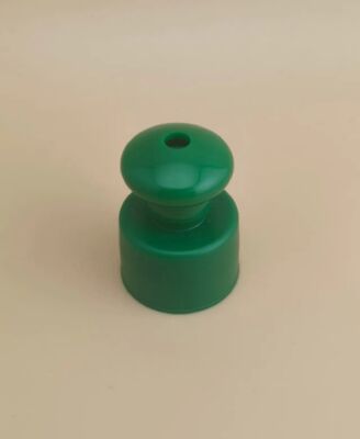 Bouchon lisse en plastique vert avec bouton pour flacons cosmétiques